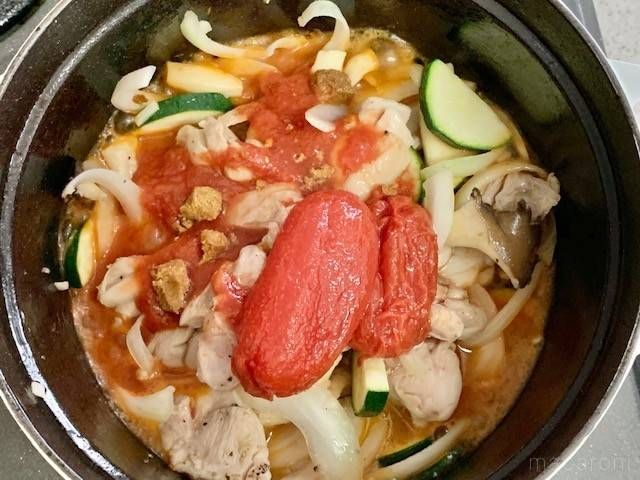 トマト缶で煮込んでいる鶏肉と野菜が入った鍋