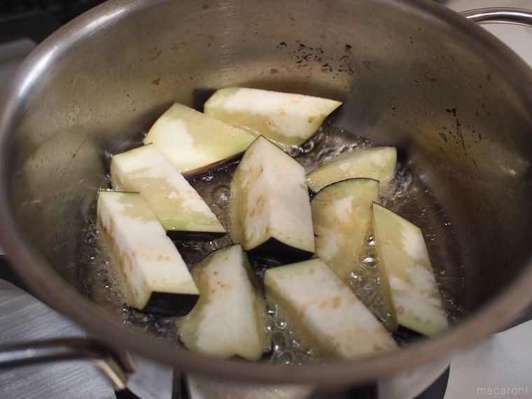 鍋でなすを揚げ焼きにする様子