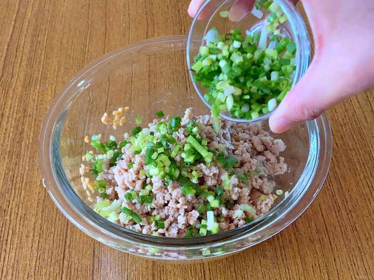 納豆に、鶏ひき肉と小口ねぎを入れる様子