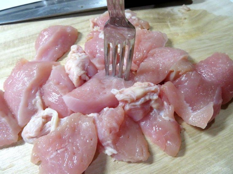 フォークで鶏肉を刺す