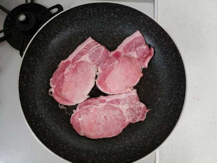 生姜焼きの豚肉をフライパンで焼く様子