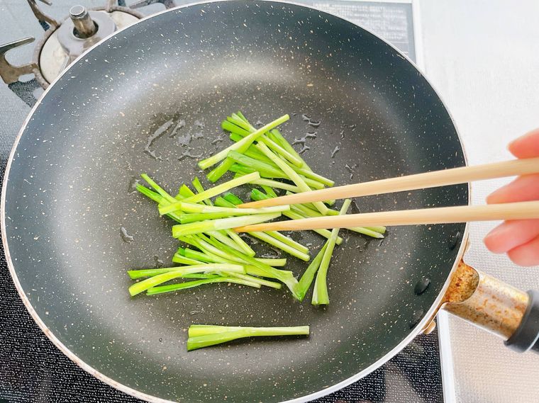 フライパンでニラの茎を炒める様子