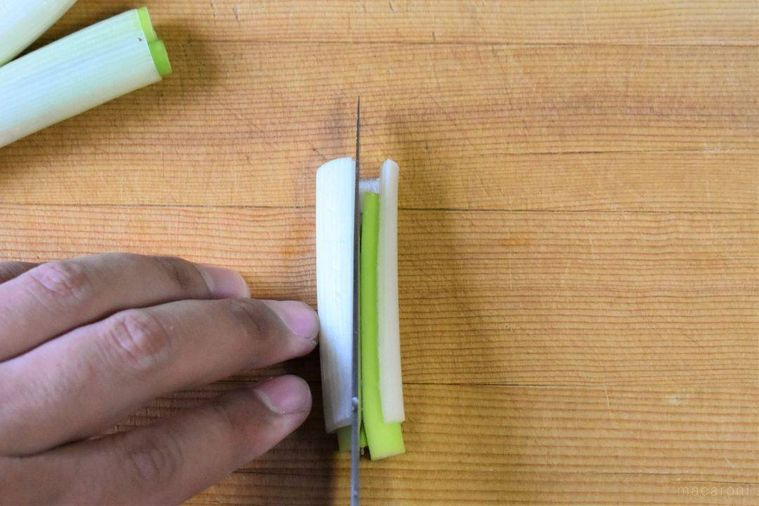 4~5cmにカットされた長ねぎに包丁を入れているところ