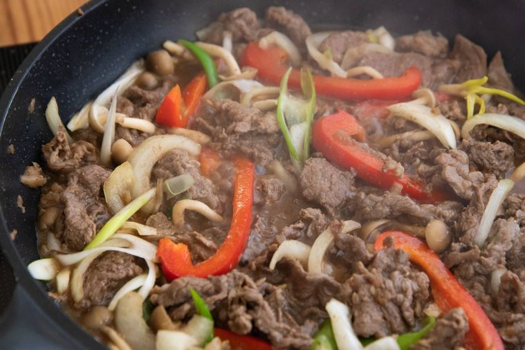 フライパンの中で野菜と肉を炒めている様子