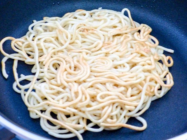 フライパンに中華麺を入れて焼く様子