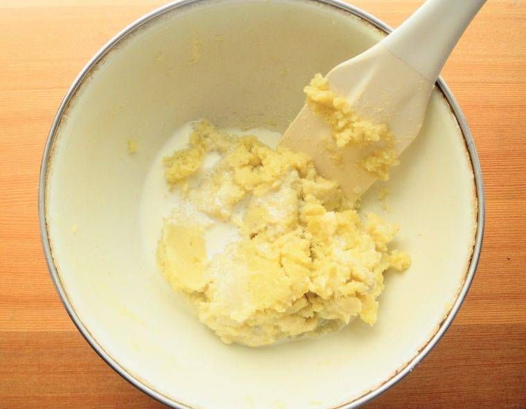 白いボウルに入ったさつまいもに、生クリームを混ぜている様子