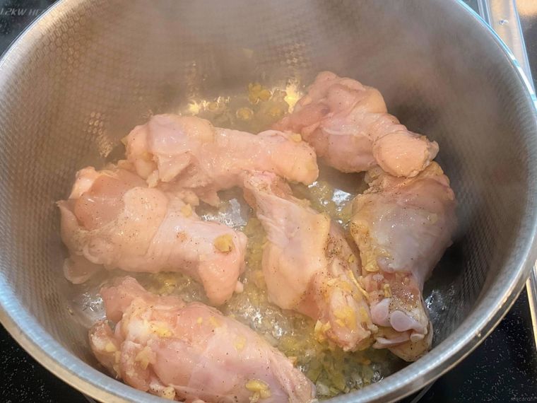 鍋で鶏手羽元を炒める様子