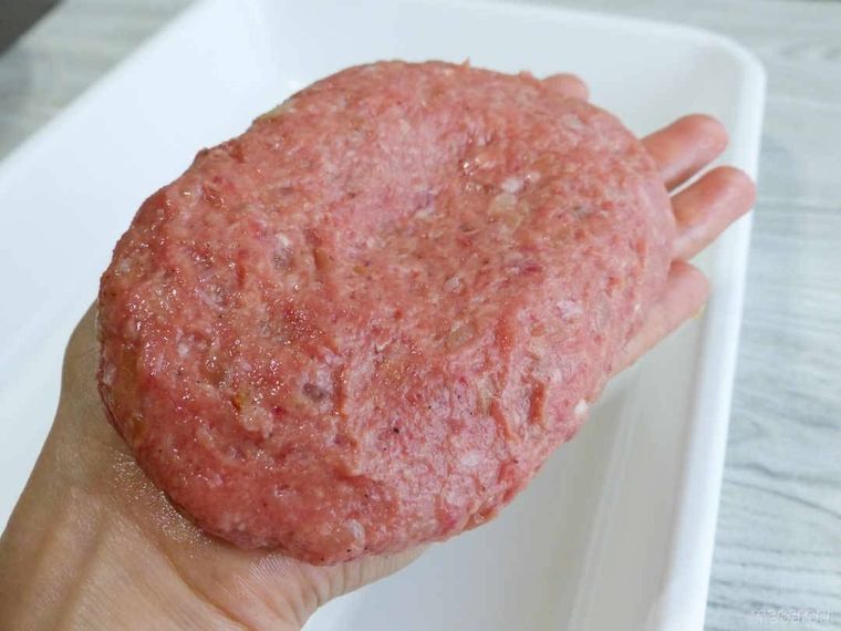 俵型に成型したハンバーグの肉ダネを持っている様子