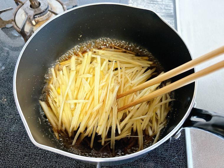 調味料が入った鍋に千切りしょうがを入れたもの