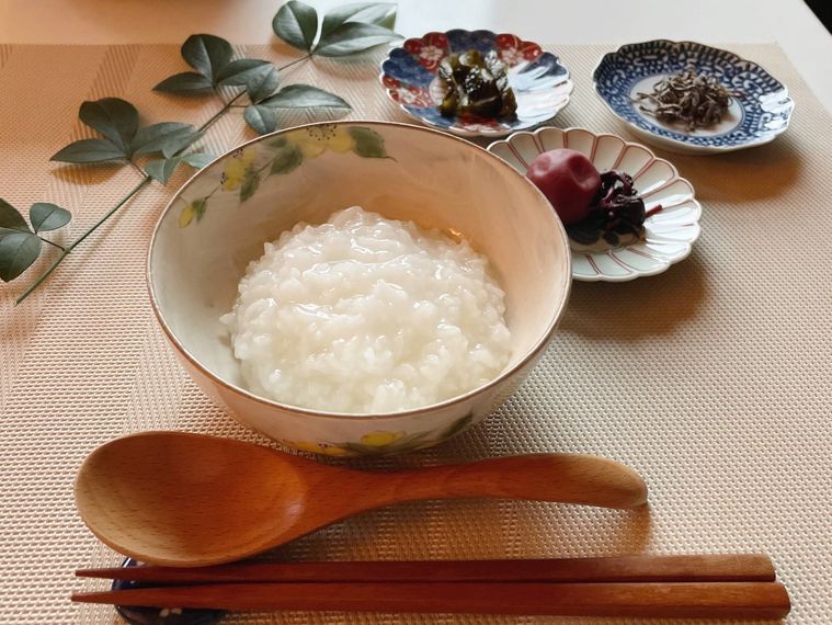 お茶碗に盛った全粥と梅干し、塩こんぶ、漬物