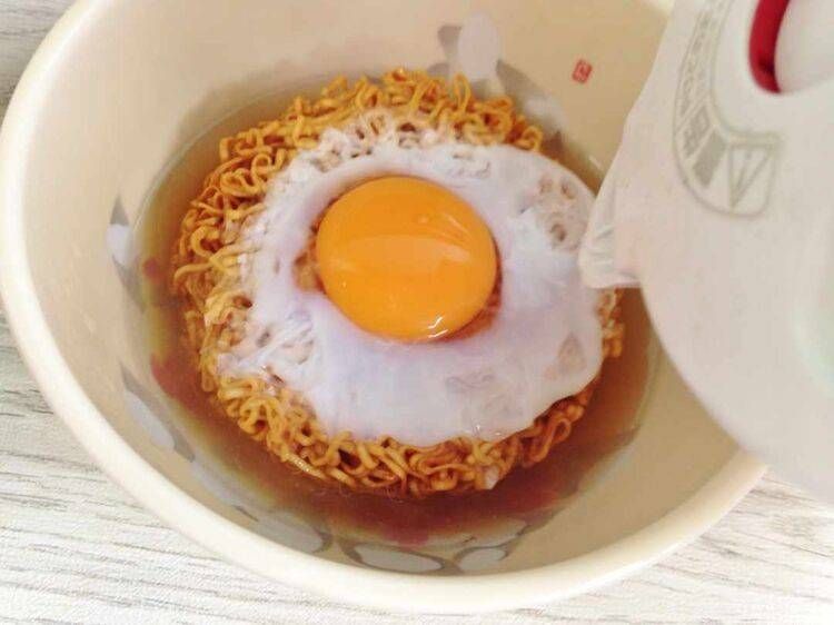 チキンラーメンに熱湯を回しかけている様子