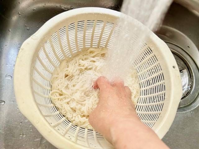 流水でぬめりを取っているそうめん