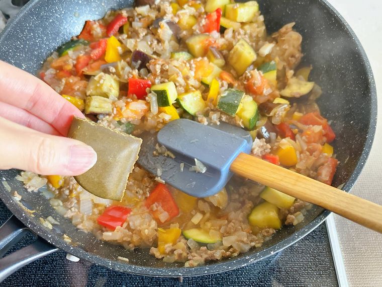 合い挽き肉と夏野菜を煮込んだところにカレールーを入れる様子