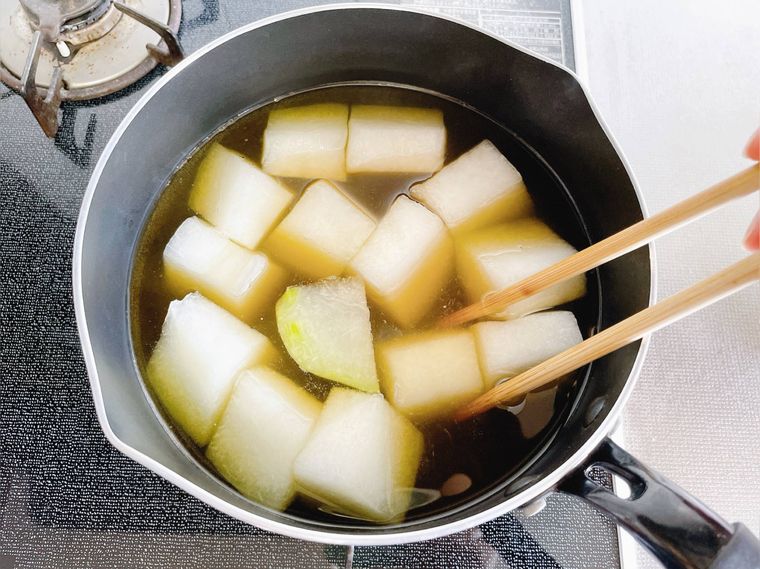 だし汁と調味料が入った鍋に冬瓜を入れる様子