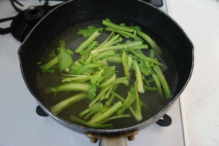 鍋に春菊の茎部分を先に入れる