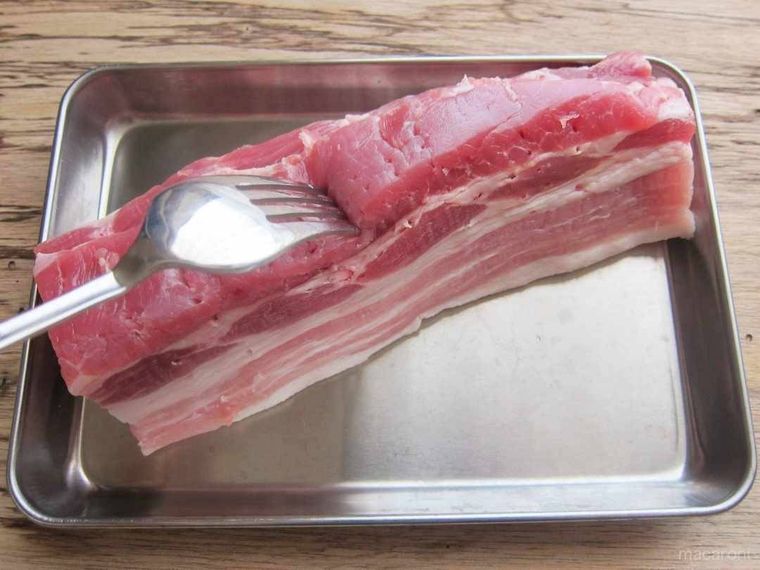 豚バラ肉にごフォークで数か所穴をあける様子