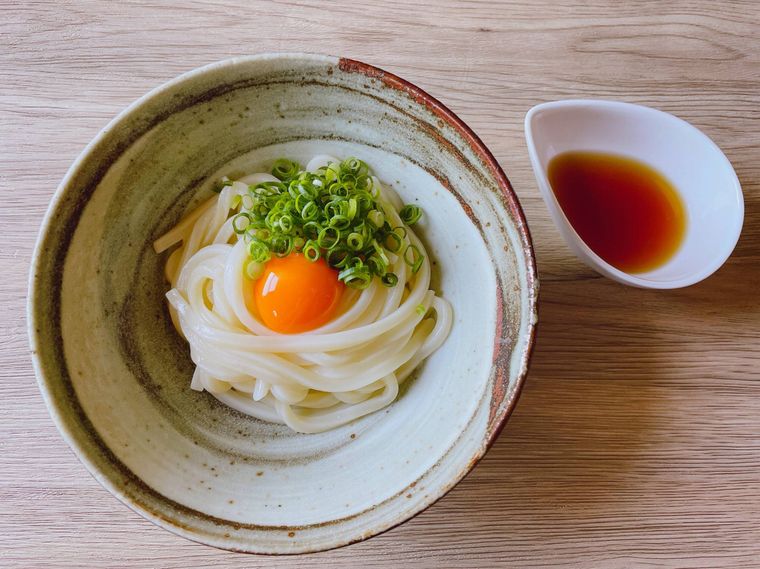 器に盛り付けた釜玉うどんとめんつゆ