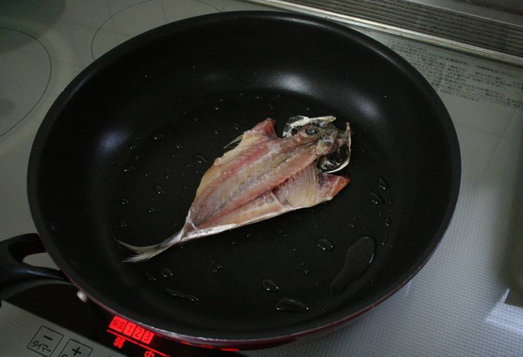 あじの干物をフライパンで皮面を下にして焼く様子