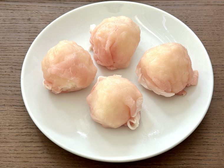 豚ロース肉を握ったごはんに巻き付けたところ