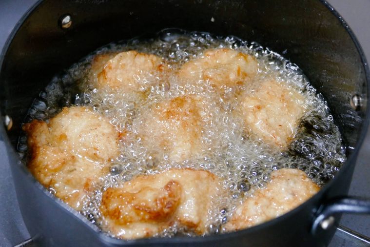 鶏むね肉を油鍋で揚げる様子