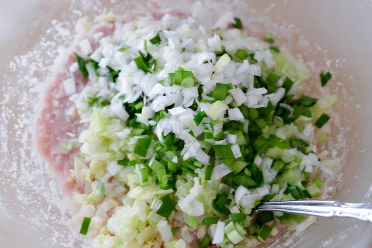 肉餡と野菜を合わせてスプーンで混ぜる様子