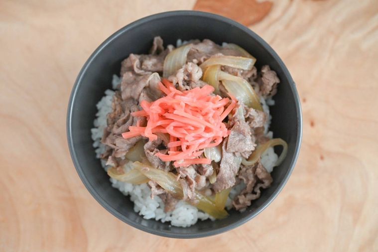 黒い皿に入った完成した牛丼