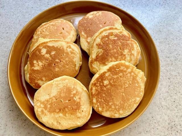 茶色の皿に入った6枚のホットケーキ