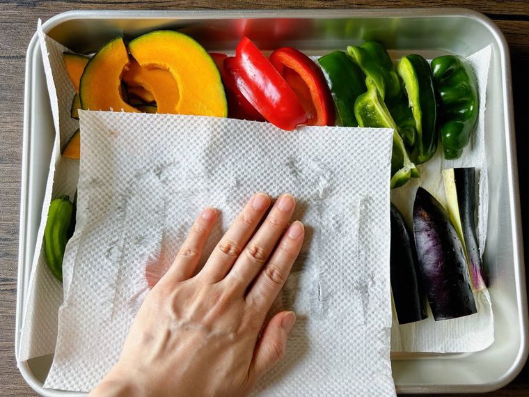 カットした野菜の水気をキッチンペーパーで拭く様子