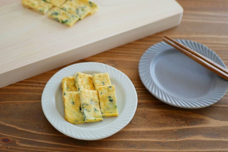 ほうれん草入りの卵焼きを盛り付ける様子