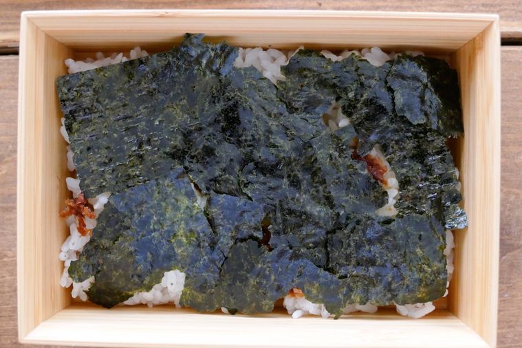 おかかしょうゆを散らしてごはんに焼き海苔をちぎって敷き詰めた様子