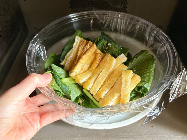 ラップをした材料が入った耐熱ボウルを電子レンジに入れる様子
