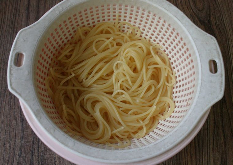 ゆで上がったスパゲッティがザルに入っている様子