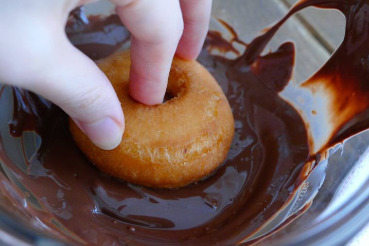 ドーナツを溶かしたミルクチョコレートにつける様子