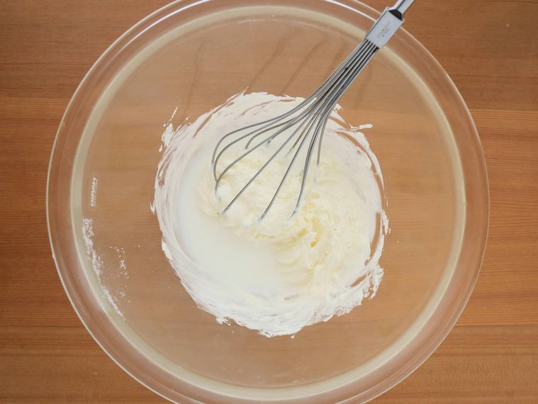 ボウルに生クリームを加え、泡立て器で混ぜる様子