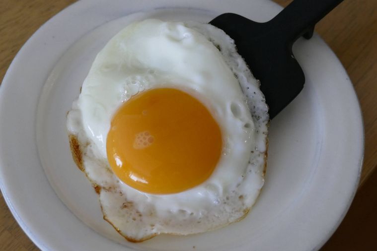 目玉焼きを皿に移す様子