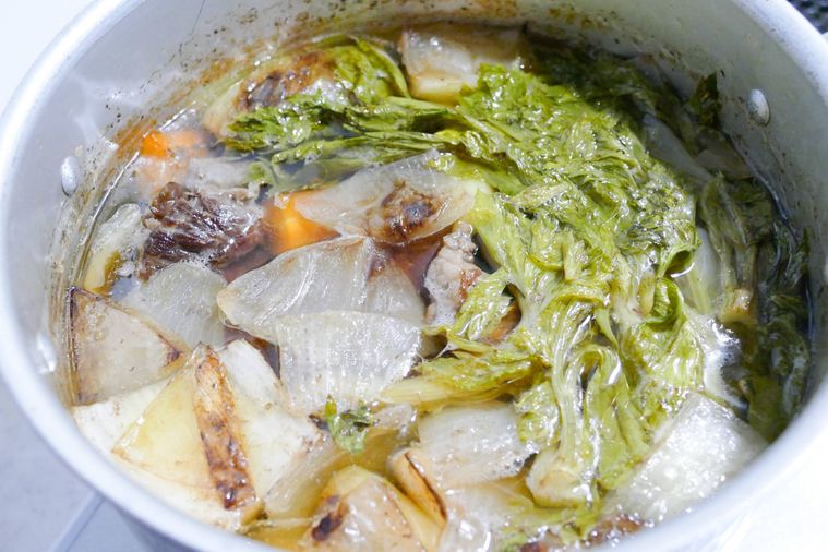 鍋で牛すじ肉と野菜を静かに煮る様子
