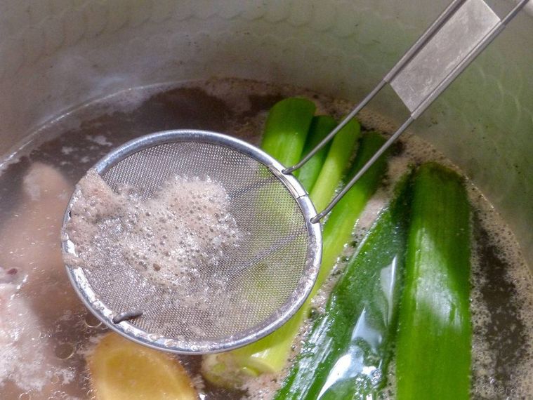 鍋の表面に浮かぶアクをあく取りで取る様子