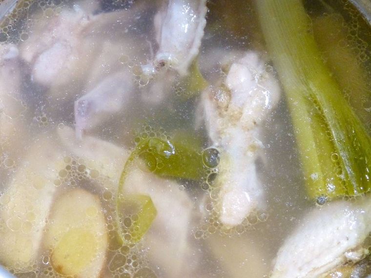 鶏肉とねぎ、しょうがを煮込む鍋の中