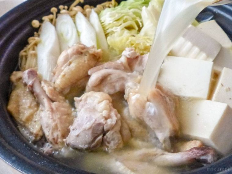 鍋に白濁スープを注ぎ入れる様子