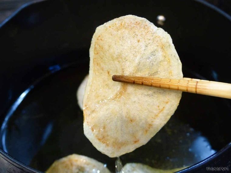 揚げたじゃがいもを菜箸で持ち上げている様子