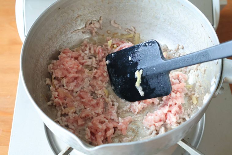 鍋で生姜とひき肉を炒めている