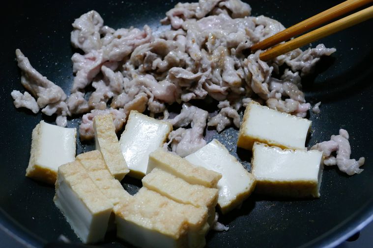 豚こま肉が入っているフライパンに厚揚げを加えた様子