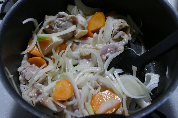 鍋で野菜と鶏もも肉を炒める様子