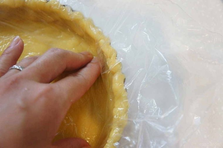 タルト生地をタルト型の底に押し当てる様子