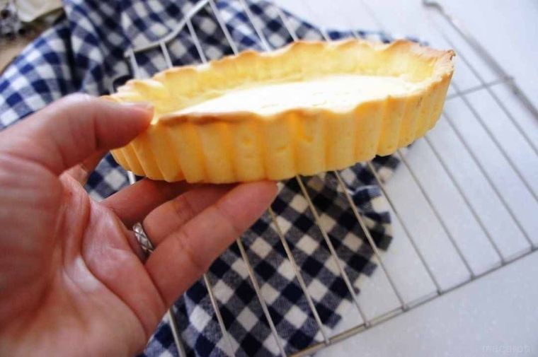 空焼きしたタルト生地を手で持っている様子