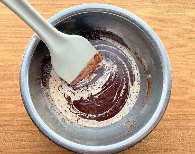 ボウルに生クリームを加え、チョコレートやバターと混ぜている様子