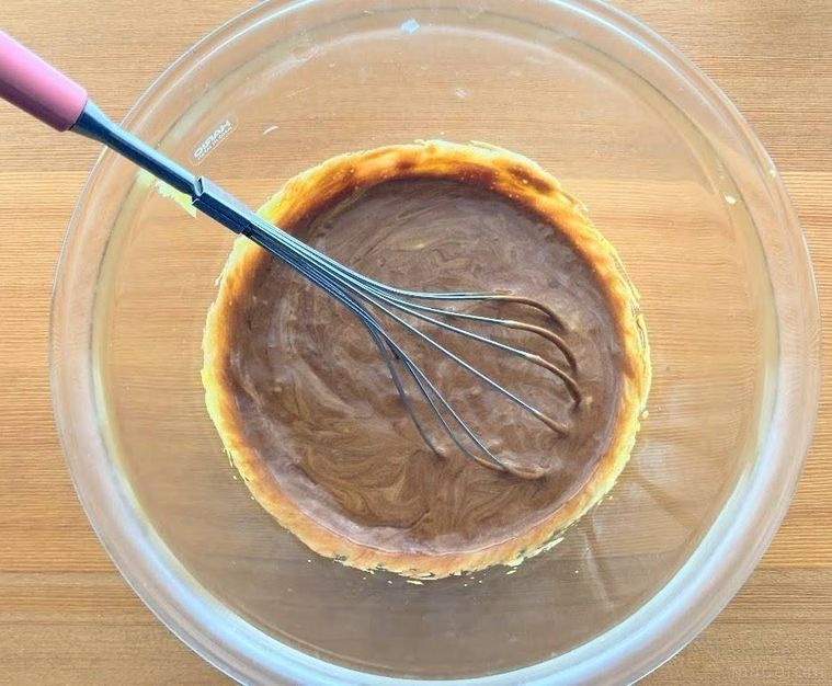 卵黄とグラニュー糖にチョコレートを加え、泡立て器で混ぜている様子