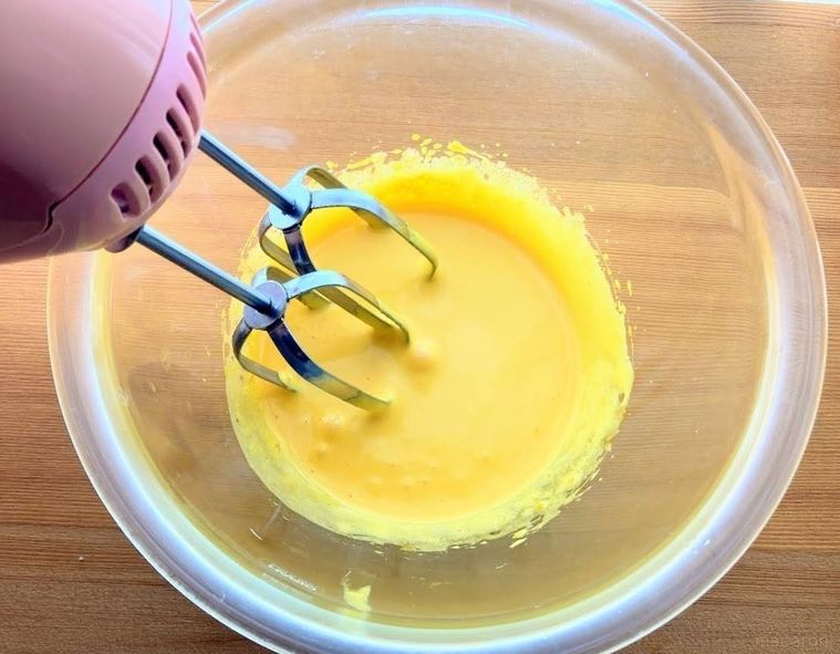 ボウルに入った卵黄とグラニュー糖を、ハンドミキサーで混ぜている様子