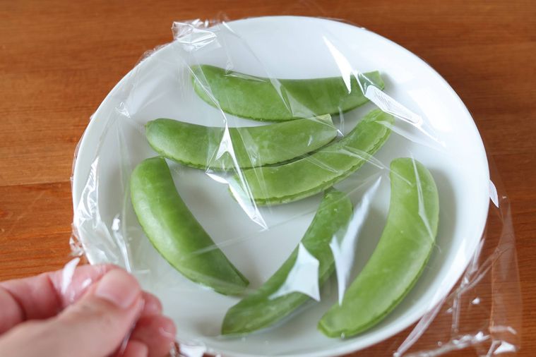 お皿にスナップえんどうを乗せラップをかけている