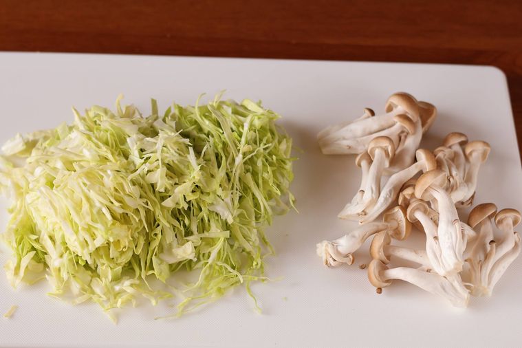 まな板の上に切ったキャベツとしめじが乗っている
